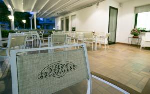 un restaurant avec des chaises et un panneau indiquant l'altararioario dans l'établissement Albergo Arcobaleno, à Sottomarina