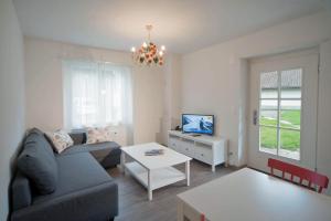 ein Wohnzimmer mit einem Sofa und einem Tisch in der Unterkunft Beausite Apartments in Interlaken