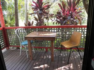 a wooden patio with a wooden table and chairs at Lake Eacham Tourist Park & Cabins in Lake Eacham