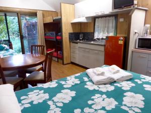 a kitchen with a table and chairs and a refrigerator at Lake Eacham Tourist Park & Cabins in Lake Eacham