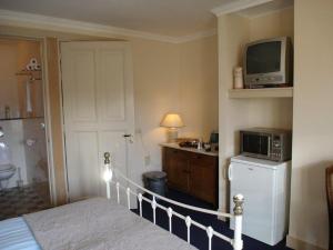 a bedroom with a bed and a microwave and a television at Logement Brocante in De Koog