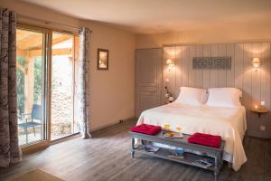 a bedroom with a bed and a large window at Le Lion D'Or en PERIGORD in Mauzac-et-Grand-Castang