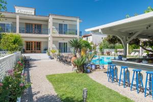 a house with chairs and a swimming pool at Hotel George in Limenas