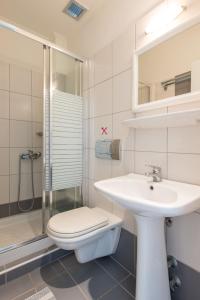 a bathroom with a toilet and a sink and a shower at Hotel George in Limenas