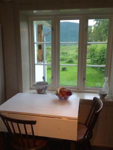 a table with a bowl of fruit in front of a window at Steigen Lodge Villa Vaag in Steigen