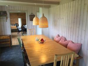 a wooden table with chairs and a bowl of fruit on it at Steigen Lodge Villa Vaag in Steigen