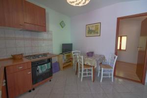 a kitchen with a table and a kitchen with a table and chairs at Darko in Veli Lošinj