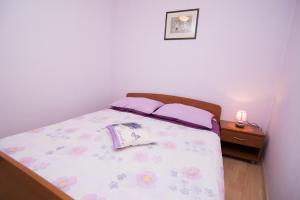 a bedroom with a bed with purple sheets and purple pillows at Darko in Veli Lošinj