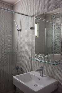 ein Bad mit einem Waschbecken und einem Spiegel in der Unterkunft Red Roof B&B in Taitung