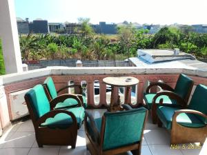 泗水的住宿－泗水科斯特48號旅館，阳台上的一组椅子和一张桌子