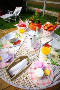 a picnic table with plates of food on it at Les Roulottes des Songes de l'Authie in Boufflers