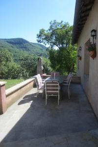 una mesa y sillas en un balcón con vistas en Maison Au Milieu De La Foret, en Labastide-Rouairoux