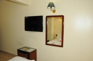 a bathroom with a mirror and a television at Nile Hotel Aswan in Aswan