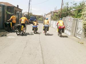a group of people riding bikes down a street at Medico and Suliko Guest House in Kutaisi