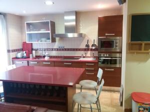 a kitchen with a red counter and chairs in it at Apartamento Pleno Centro Gran Via in Logroño