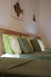 a bedroom with two beds with green and white pillows at Casa Noemi b&b in Uggiano la Chiesa
