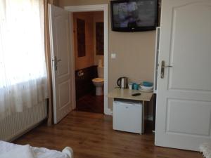 a bathroom with a toilet and a television on the wall at Villa Karolina in Mielno