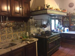 a kitchen with a black stove top oven in a kitchen at Centro Trekking A Cavallo Monte Brugiana in Massa
