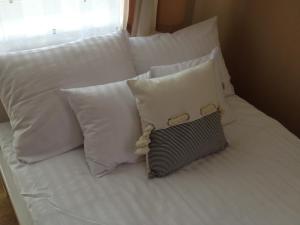 a white bed with white pillows on it at Villa Karolina in Mielno