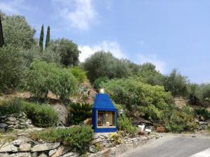 ドルチェアックアにあるIl Giardino Degli Uliviの道路脇に座る青い家