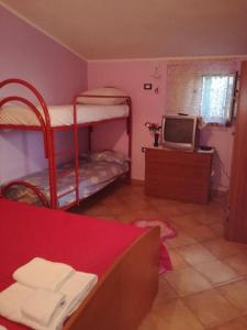 a room with two bunk beds and a television at Villa Rosa Maria in Villaggio Mosè