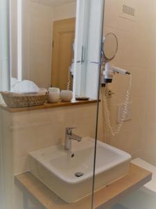 uma casa de banho com um lavatório e um espelho em Landhotel Restaurant Hubinger em Thörl
