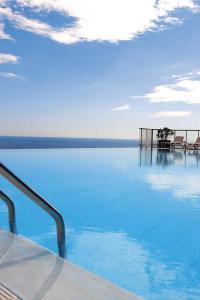カップ・ダイユにあるAppt 5 personnes vue mer piscine Costa Plana Cap d'Ail Monacoの青い水のプールの景色を望む客室で、椅子が備わります。