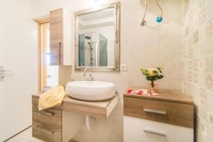 a bathroom with a sink and a mirror at Charming house on the beach and Deluxe Apartment in Pula