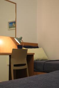 a bedroom with a desk with a bed and a lamp at Casa Noemi b&b in Uggiano la Chiesa