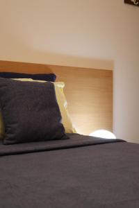 a bed with a wooden headboard and a pillow at Casa Noemi b&b in Uggiano la Chiesa