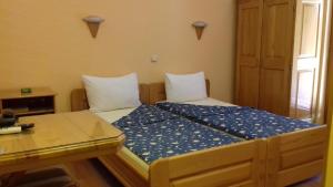 a small room with two beds with a glass table at B&B Boem in Požarevac