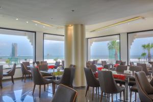 - un restaurant avec des tables et des chaises et une vue sur l'océan dans l'établissement Le Rio Appart-Hotel City Center, à Tanger