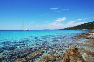 a sail boat in the water next to a beach at Apartment Natalie Sea View with 3 Bedrooms and everything is air-conditioned in Sali