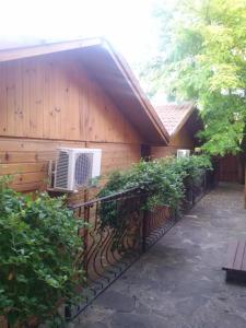 a building with a fence with an air conditioner on it at Zlatnoto Pile Restaurant & Rooms in Kranevo +12 photos