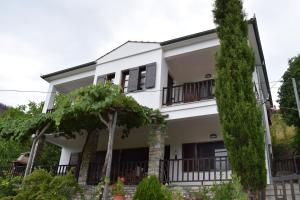 una casa blanca con árboles delante de ella en Aspasia's Villa, en Prinos