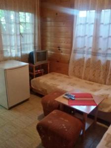 a room with a bed and a table and a tv at Zlatnoto Pile Restaurant & Rooms in Kranevo