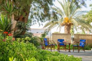 un patio con sillas, una mesa y una palmera en Sea and Sun, en Amoudara Herakliou