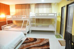 Zimmer mit 2 Etagenbetten und einem Teppich in der Unterkunft Zeala Asmara Motel in Kuah