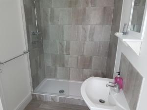 a bathroom with a shower and a sink and a tub at The Craigside in Skegness