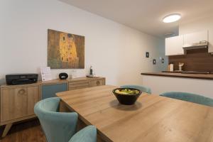 ein Esszimmer mit einem Holztisch und blauen Stühlen in der Unterkunft Mar Suite Apartments - Simmering in Wien