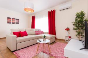 sala de estar con sofá blanco y cortinas rojas en Casa Lagos, en Lagos