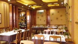 a dining room with white tables and chairs and a room filled with tables and chairs at B&B Boem in Požarevac
