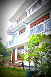 a building with a wooden bench in front of it at Jaya Tomodachi in Kandy