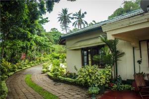 Ancoombra Tea Estate Bungalow في ماتالي: منزل به ممشى من الطوب بجانب مبنى