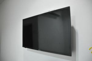 a flat screen tv hanging on a wall at Zeala Asmara Motel in Kuah