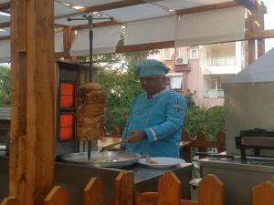 a man preparing food on a grill in a kitchen at Esperanza Hotel in Antalya +115 photos