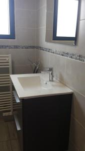 a bathroom with a white sink and a window at Le Chalet de l'Authie in Saulchoy +3 photos