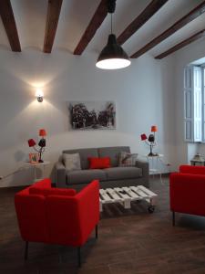 a living room with a couch and red chairs at Valencia what else... in Valencia