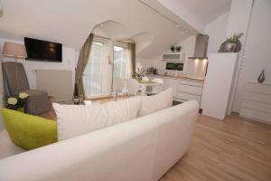 sala de estar con sofá blanco y cocina en York Cottage en Traben-Trarbach