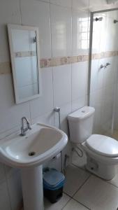 Un baño blanco con lavabo e inodoro. en Pousada Anhanguera, en Ribeirão Preto 33 fotos más